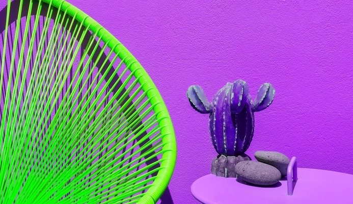 green weaved chair with purple background
